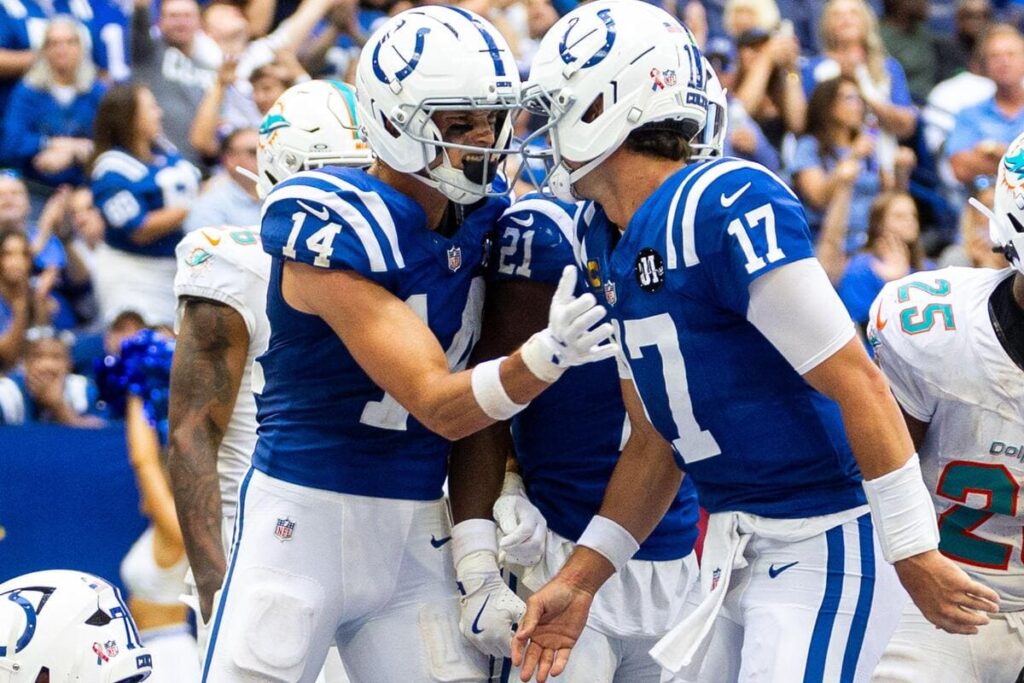 O quarterback do Indianapolis Colts, Daniel Jones, comemora um touchdown com seus companheiros de equipe.