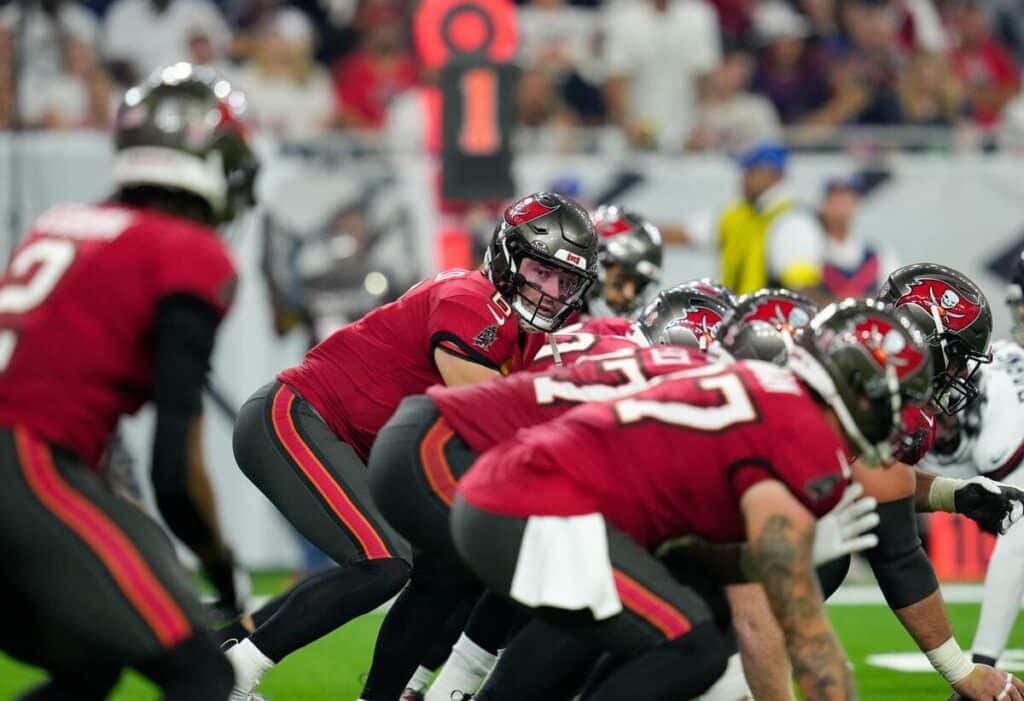 Квотербек Tampa Bay Buccaneers Бейкер Мэйфилд смотрит на своего принимающего, стоя под центром.