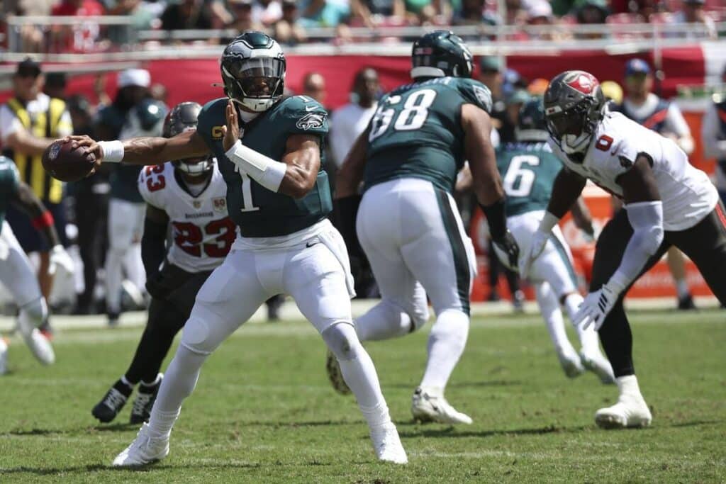 Philadelphia Eagles quarterback Jalen Hurts winding up to throw a pass during a game.
