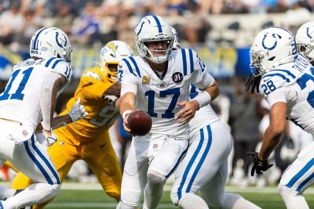 Indianapolis Colts quarterback Daniel Jones handing off a football during a game.
