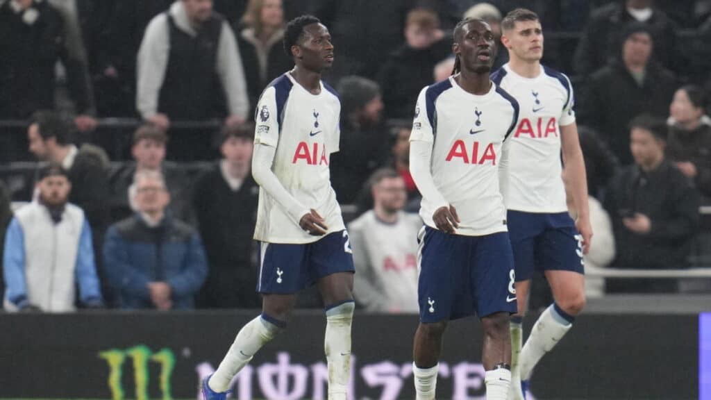 Tottenham players walking dejected after conceding a goal