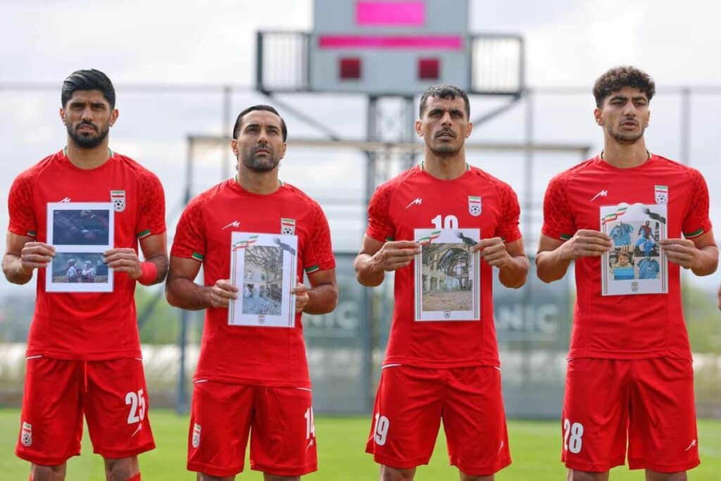Iran's players hold up pictures of the victims of US-Israeli airstrikes.