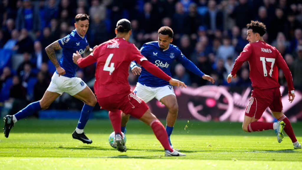 Liverpool and Everton players battle