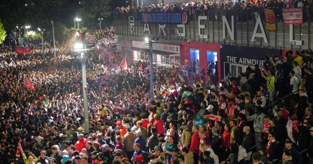 Arsenal fans celebrating outside Emirates Stadium following their Premier League title win