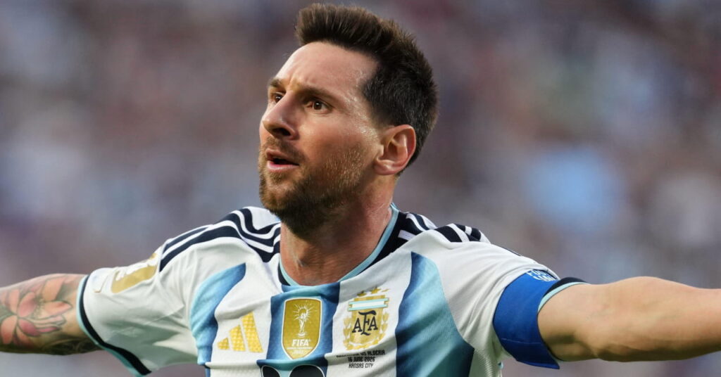 Argentina footballer Lionel Messi playing for his national football team in a blue and white shirt with his number 10 in black on the chest and his arms outstretched