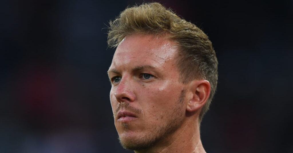 Uma foto do técnico de futebol e técnico da Alemanha, Julian Nagelsmann, de pé e olhando para dentro de um estádio