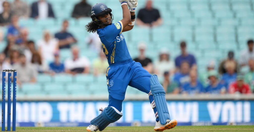 A photo of a women's player in a blue kit hitting a shot with a bat in cricket competition The Hundred 2026
