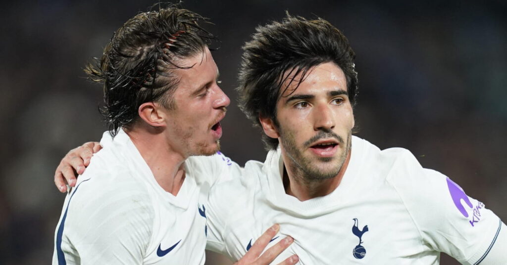 Footballer Sandro Tonali receiving congratulations after scoring a goal for Tottenham Hotspur Football Club while wearing the white Spurs home kit with the club cockerel badge on the chest