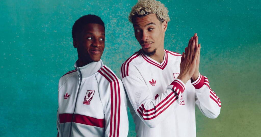 Footballers Hugo Ekitike and Trey Nyoni looking at each other while wearing the Adidas Liverpool Football Club Premier League away kit of white with red trim