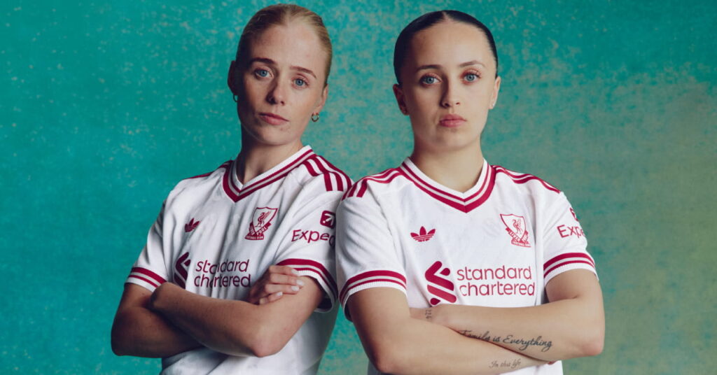 Footballers Grace Fisk and Mia Enderby wearing the Adidas Liverpool Football Club Premier League away kit of white with red trim