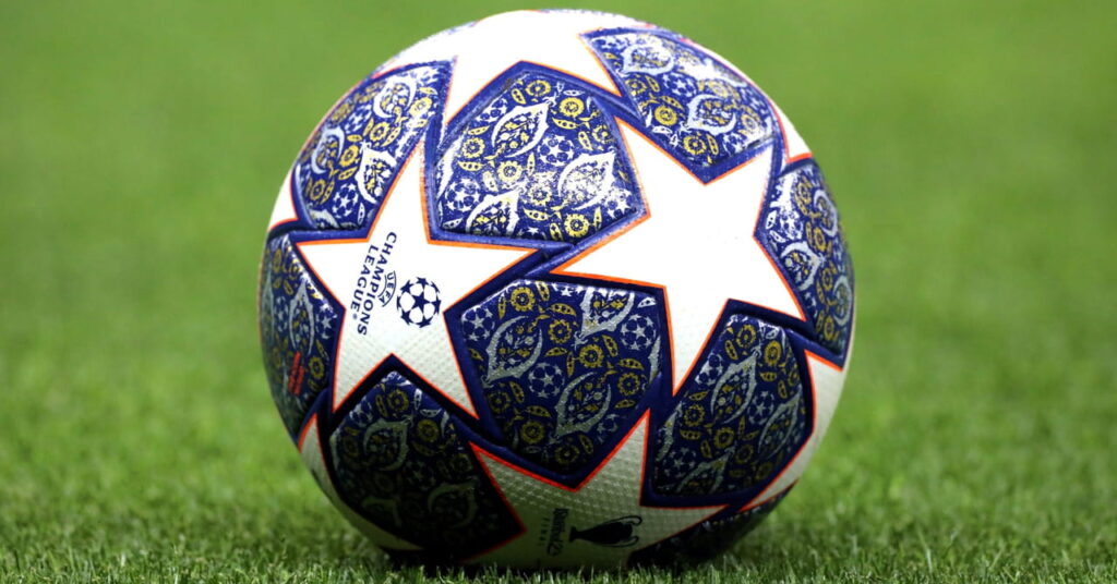 The blue and white ball of European football competition the UEFA Champions League on a green pitch