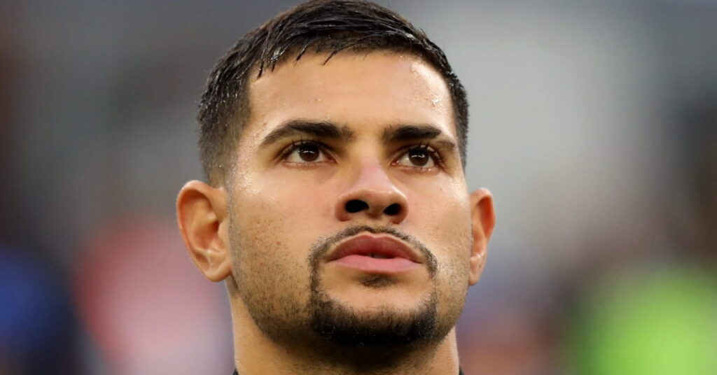 Brazil footballer Bruno Guimaraes playing for Premier League team Newcastle United Football Club while wearing a black tracksuit top with white trim and the club badge on the chest