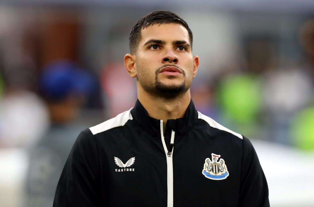 Brazil footballer Bruno Guimaraes playing for Premier League team Newcastle United Football Club while wearing a black tracksuit top with white trim and the club badge on the chest