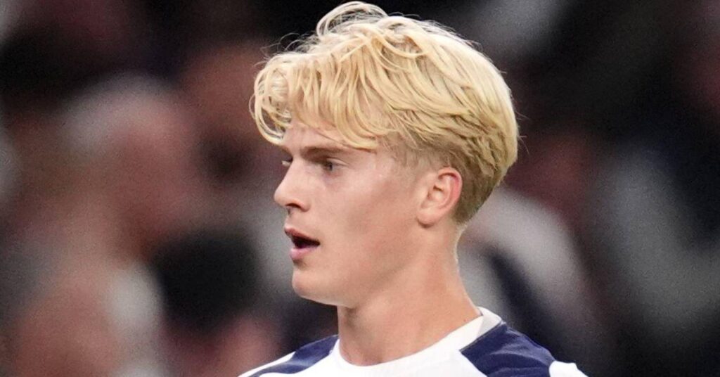 O jogador de futebol Lucas Bergwall olha para a direita enquanto joga com uma camisa branca em um campo pelo time da Premier League Tottenham Hotspur Football Club