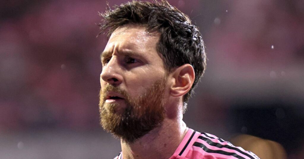 Argentina footballer Lionel Messi looking to his right while playing in Major League Soccer for MLS team Inter Miami in a pink shirt with black trim in a stadium