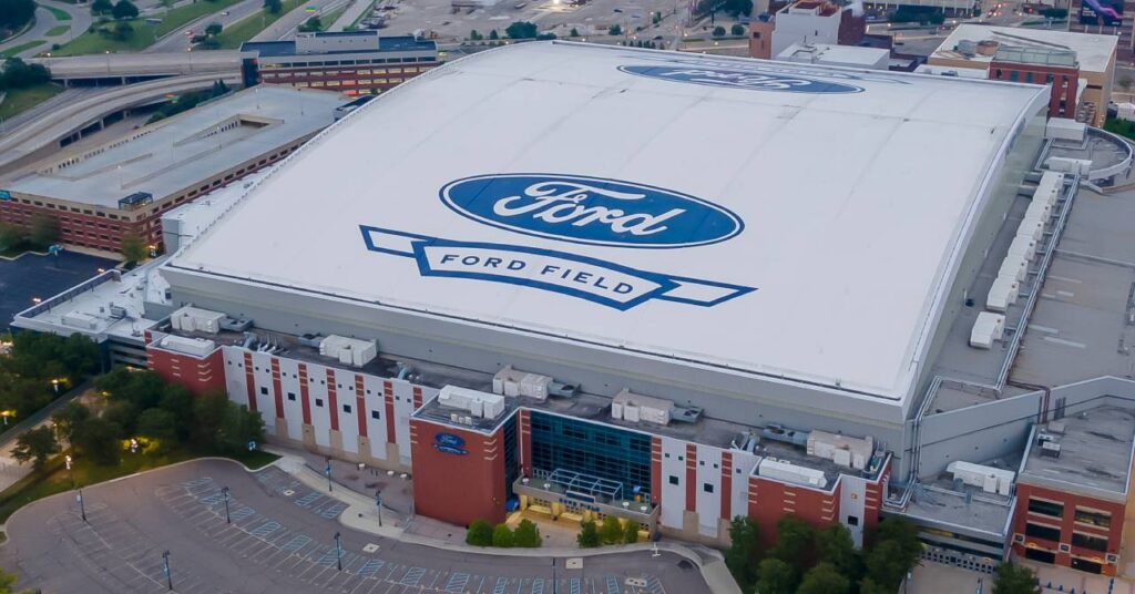 An overhead view of the Ford Field National Football League American football stadium home of NFL team the Detroit Lions, showing the Ford logo in a blue on a white roof and a surrounding residential area