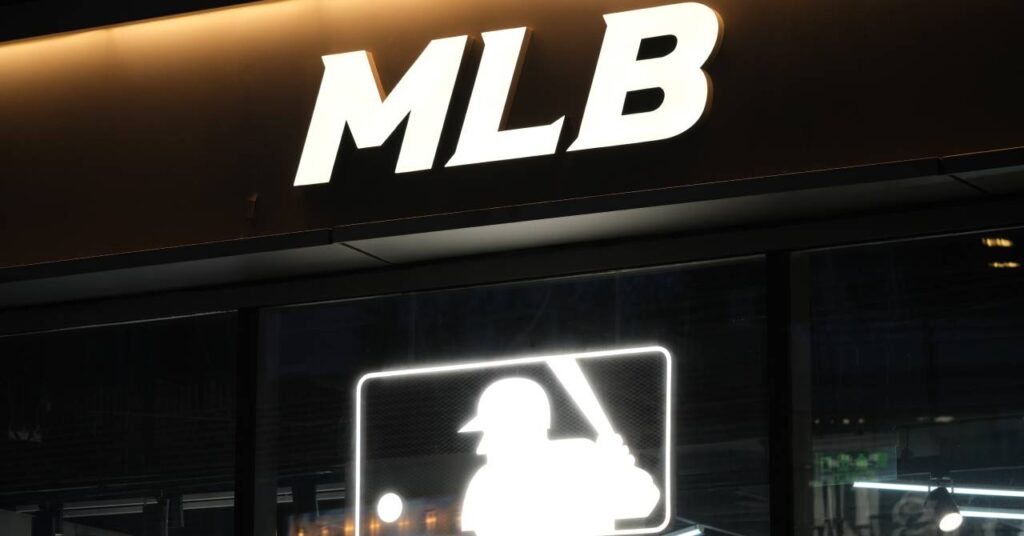 The letters MLB above the Major League Baseball logo in white on a darkened building