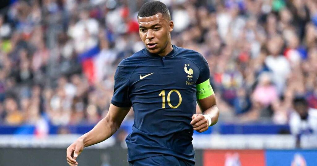 Kylian Mbappe, jogador da La Liga, jogador de futebol do Real Madrid Football Club, veste camisa azul da seleção francesa, braçadeira de capitão verde no braço esquerdo, número 10 e logotipo da Nike no peito.