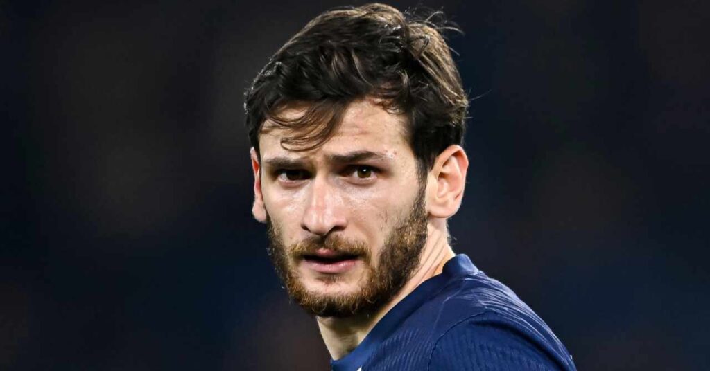 A jogadora de futebol da Geórgia, Kwicha Kvaratskelia, joga no Paris Saint-Germain Football Club, da Ligue 1, e usa uma camisa azul escura do PSG em campo.